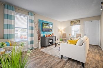 Open floor plan living room with ample natural light and plank flooring at 701 south apartments in mobile, al